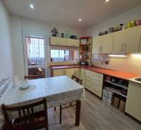 A kitchen in a 3-room apartment with a wooden decor floor and a dining table.
