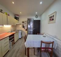A kitchen in a 3-room apartment with a wooden decor floor and a dining table.