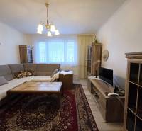 Living room in a 3-room apartment with a corner sofa and a floor with a wooden decor.