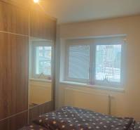 Bedroom in a family house with a large wardrobe and a bed with star-patterned bedding.