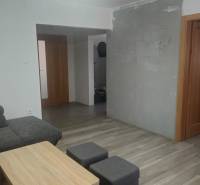 Living room in a family house, gray sofa, wooden coffee table, floor with wooden decor.