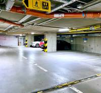 Underground garages with vehicles in parking spaces and elevator signs.