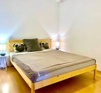 Bedroom in a 2-room apartment with wooden decor and pillows on the bed.