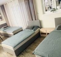 Three beds, two nightstands, and a wooden-decor floor in a family house.