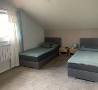 Double room in a family house with carpet and skylight.