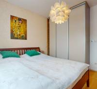 Bedroom in a 4-room apartment with a painting on the wall and a floor with a wooden decor.