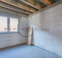 A building with white walls and a large window opening in the building.