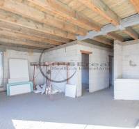 A building under construction with a wooden ceiling and construction materials inside.