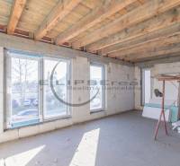 Building in Veľké Leváre with large windows and a wooden ceiling, preparation for the interior.