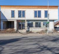 A building in Veľké Leváre with an unfinished facade standing by the road.