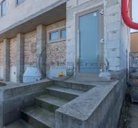 A building in Veľké Leváre with an unfinished facade and stairs on a concrete base.
