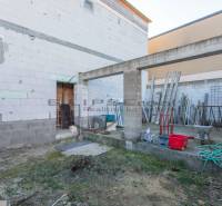 Construction site in Veľké Leváre with materials and tools near a building made of concrete blocks.