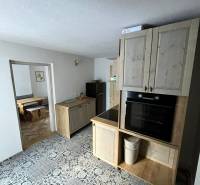 A kitchen in a family house with patterned tiles and kitchen cabinets with a wood decor.