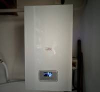 A condensing boiler in the interior of a family house with the current temperature displayed on the screen.