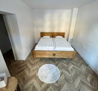 Medium-sized bedroom in a family house with a double bed and a wooden decor floor.