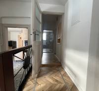 A hallway in a family house with a wooden decor floor and open doors.