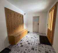 A hallway in a family house with colorful tiles and wooden elements.