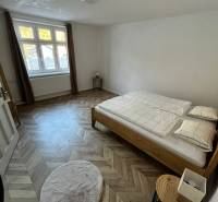 A bedroom in a family house with a wooden decor floor and a wooden bed.