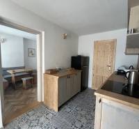 Kitchen in a family house with colorful tiles, wooden decor, and entrance to the dining room.