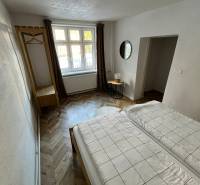 Bedroom in a family house with a wooden decor floor and a large window.
