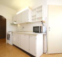 Kitchen unit with a microwave in a 2-room apartment, floor with wooden decor.