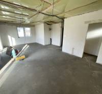 The interior of a family house with an unfinished floor and an unfinished ceiling.