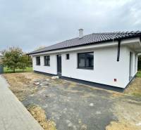 A family house in Sol with a white facade and a sloped roof, surrounded by a garden.