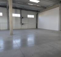 Spacious interior of warehouses and halls with concrete flooring and high ceilings.