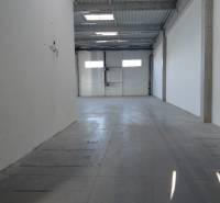 Empty interior of warehouses and halls with white walls and concrete floor.