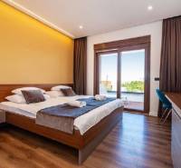 Elegant bedroom in a villa with a bed and wooden decor flooring.