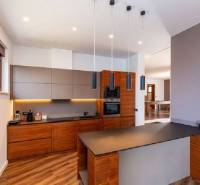 A kitchen in a villa with a wood-patterned floor and stylish lighting.