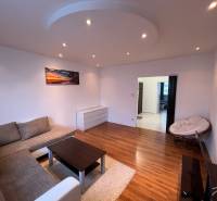 Living room in a 3-room apartment with a comfortable sofa and a floor with a wooden design.