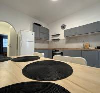A kitchen in a 3-room apartment with a simple design and a dining table with placemats.