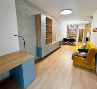 Living room in a two-room apartment with a wooden decor floor and furniture.