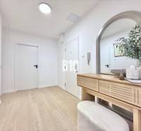 Entrance hall in a 3-room apartment, with a mirror, wooden decor, and decorations.