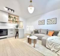 Living room with a kitchenette and a wooden decor floor in a 3-room apartment.