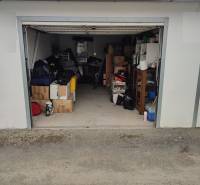 An open garage on Urxova Street in Prešov with various stored equipment and furniture.