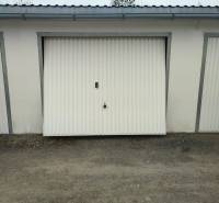 Garage on Urxova Street in Prešov with white doors on a gravel surface.