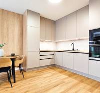 A kitchen in a 2-room apartment with a wooden decor floor and a dining table.
