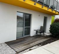 On Brečtanová Street, there is a terrace of a 2-room apartment with seating by the garden.