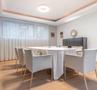 Dining room in a 4-room apartment with a wooden decor floor and light curtains.