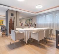 Dining room in a 4-room apartment with wood-patterned flooring, a round table, and art on the walls.
