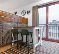 Dining area with chairs in a 4-room apartment with a striped carpet.