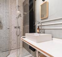 Bathroom with a shower, sink, and tile decor in a four-room apartment.