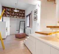 Interior of a 4-room apartment with shelves, stairs, and flooring with a wood decor.