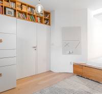 Interior of a 4-room apartment with bookshelves, built-in wardrobes, and flooring with a wood decor.