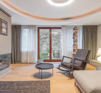 Living room in a 4-room apartment with a wooden decor floor, a fireplace, and a comfortable armchair.