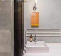 Bathroom in a 4-room apartment with a sink and shower, gray tiles.