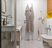 Bathroom with a shower, sink, toilet, and towels in a 4-room apartment.