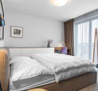 A bedroom in a 4-room apartment with a large window, a desk, and a comfortable bed.